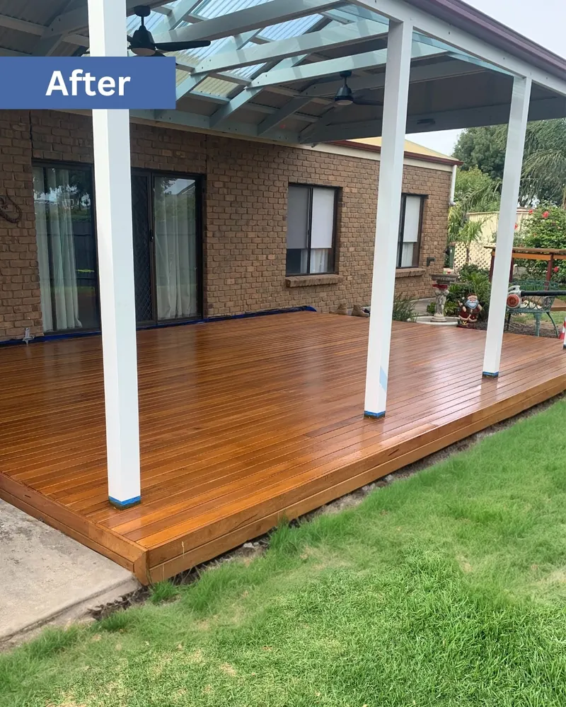 New oiled hardwood deck under the verandah with white posts, same home after the build
