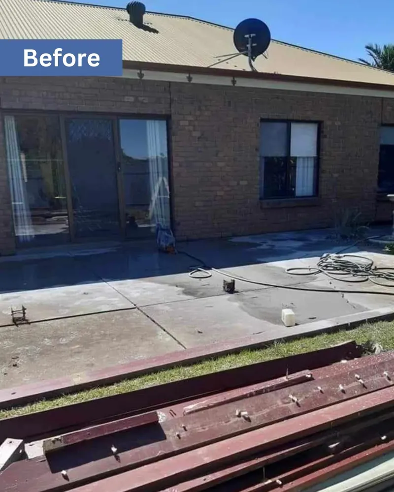 Concrete slab and old paving beside a brick home before the deck was built
