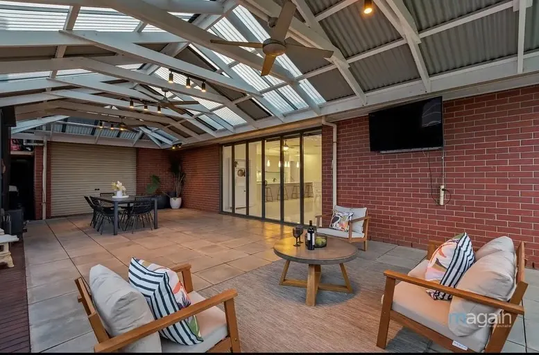 Outdoor lounge furniture on a timber deck under a pergola roof