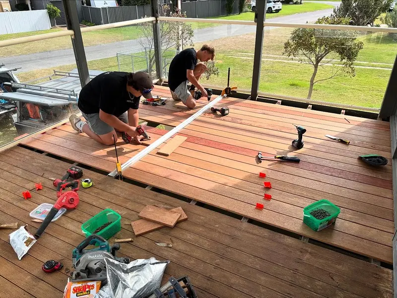 Deck builders measuring and fixing boards on a covered deck in Adelaide