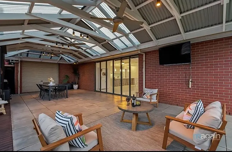 Outdoor lounge furniture on a timber deck under a pergola roof